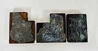 Top view of three antique wood letterpress print blocks showing engraved metal surfaces with scenes of young people playing, Victorian musicians, and people playing.