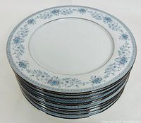 Stack of 11 Noritake Blue Hill dinner plates showing the decorative blue floral and silver trim edges.