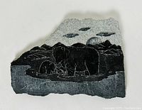 Front view of rectangular soapstone carving depicting bear family with mountain and cloud background, signed and polished.