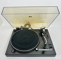 Front view of Sanyo TP-1020 turntable with clear dust cover open, showing platter with rubber mat, tonearm, and control panel.