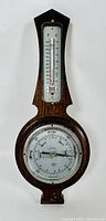 Front view of the wooden barometer and thermometer with clear visibility of dial and scale.