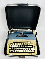 Top-open view of the Smith-Corona typewriter showing keyboard, platen rollers, and case interior.