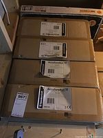 Four sealed cardboard boxes of SpeakerCraft AccuTune 10 stacked in rafters, showing labels with product name and barcodes.