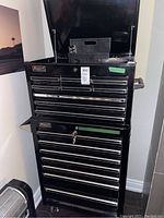 Full front view of black Homak professional tool chest and rolling cabinet on caster wheels