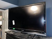 Front view of the Sharp 37-inch LCD television showing the black frame and reflective screen surface.