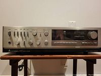 Front view of Mitsubishi DA-R25 stereo receiver showing control knobs, switches, and display panel.