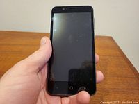 Front view of locked ZTE Fanfare 3 phone with screen off held in hand