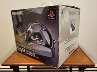 Original Mad Catz PlayStation Racing Wheel box showing wear and damage on exterior.