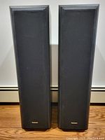 Front view of two standing speakers with black fabric covers and Technics logo at bottom