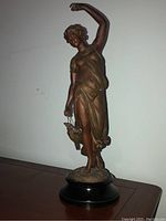 Full view of sculpture on furniture surface against white wall