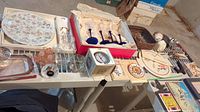 Wide view of various kitchen items including floral plates, stemware, and small accessories on table