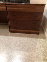 Front view of wooden file cabinet showing two drawers with vintage-style metal handles.