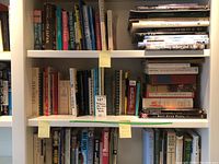 Bookshelves with multiple books including various subjects and some vintage looking volumes.
