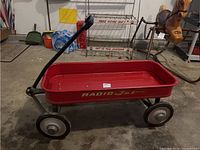 Full side profile of the red wagon with visible handle and four wheels.