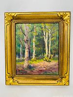 Frontal photo of the framed painting showing the impressionist forest scene and gilded frame