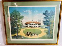 Framed print showing a grand colonial mansion with a horse-drawn carriage in the front, set within a green matted frame under glass.