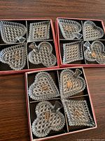 Three sets of clear Czech glass trinket dishes in original boxes, each box containing four dishes representing the four card suits with black compartment dividers.