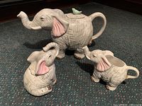 Full view of the three-piece elephant tea serving set featuring teapot, sugar bowl with lid, and cream pitcher resembling elephants.