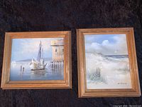Two framed canvas paintings side by side on dark background