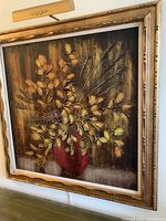 Full view of large framed floral oil painting showing detailed gold frame and mounted light