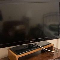 Front view of Samsung 40 inch LCD TV on black stand showing the screen and base.