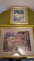 Two framed prints against a wall showing angelic children in nature scenes