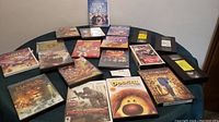 Photo showing a spread of DVDs and VHS tapes featuring various titles including Disney Frozen, Dumbo, Toy Story 2, and more