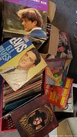 Two crates filled with a large collection of vinyl records with visible covers including Elvis Presley 'GI Blues' and Charley Pride 'Greatest Hits' among others.