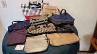 Full view of 10 assorted purses and bags on table showing size and color variety.