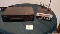 Photo showing Sharp VCR and RCA CB radio on a table with labels, untested condition