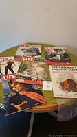 Six vintage magazines - five Life magazines dated from 1945 to 1968 and one The Saturday Evening Post from 1909 arranged on a table