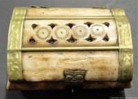 Top view showing circular carved details and brass edge accents on the bone box.