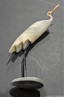 Side angle showing detailed wing carving and metal stand