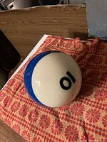 Photo showing top view with number 10 on white and blue billiards ball.