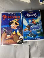 Two Disney VHS tapes: Pinocchio and The Rescuers, showing front cover artwork.