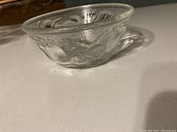 Close-up image of clear glass bowl with embossed textured floral or leaf design.
