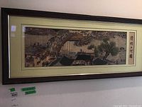 Full view of the framed silk embroidery showing the entire river and market scene with the frame and mat.