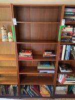 Front view of the wood veneer bookshelf filled with some books on adjustable shelves.