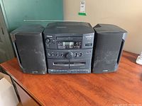 Front view of Samsung karaoke stereo mixing system with two speakers showing control panel, cassette decks, and antenna.