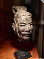 Close-up angled view of samurai bust showing detailed facial features and hair.
