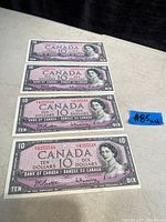 Four stacked purple 1954 Canadian ten-dollar bills displaying Queen Elizabeth II portrait and bilingual text.