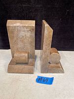 Pair of marble Art Deco book ends shown from the front and side angles on a dark background.