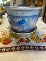 Porcelain flower pot and matching tray showing floral patterns and Greek key border.