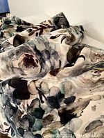 Close-up of the cotton velvet fabric showing detailed floral pattern with green, brown, and muted tones.
