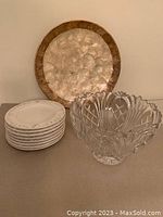 Lot contents showing stacked dessert plates, decorative silver-tone plate behind, and clear cut crystal bowl in front
