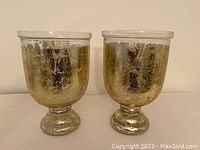 Pair of large glass candle holders with a distressed gold glaze, shown side by side.