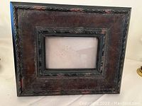 Distressed dark wooden picture frame with carved edges, fitting 4x6 photos