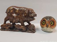 Front view of pig with four piglets figurine and owl figurine side by side.