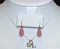 Front view of necklace with pendants and rose quartz tear drop earrings displayed on white bust