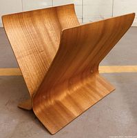Side angled view showing curved wood panels and V shape of magazine holder